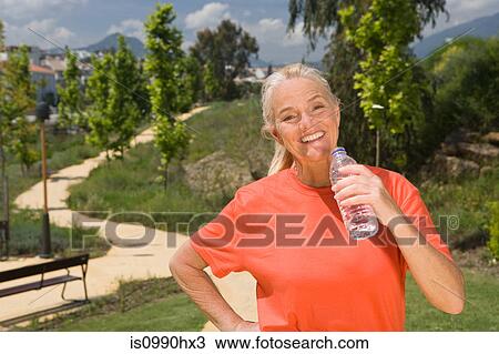 Mature woman runner with bottle of water View Large Photo Image Stock Image - Mature woman runner with bottle of water. Fotosearch