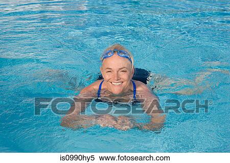 Stock Photography - Mature woman swimming in pool. Fotosearch