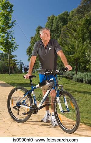 Senior male cyclist with bicycle View Large Photo Image Stock Image - Senior male cyclist with bicycle. Fotosearch