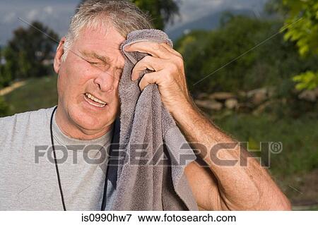 Senior man wiping face with towel after workout View Large Photo Image Stock Photo - Senior man wiping face with towel after workout. Fotosearch