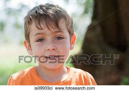 Stock Image - Boy wearing orange t shirt, portrait. Fotosearch