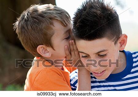 Stock Image - Boy whispering to firiend. Fotosearch