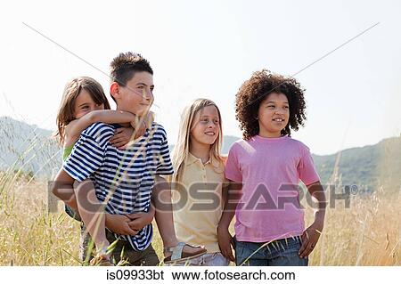 Four friends in field, youngest girl having piggy back View Large Photo Image Stock Photograph - Four friends in field, youngest girl having piggy back. Fotosearch