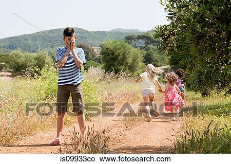 Four friends playing hide and seek on country road View Large Photo Image Picture - Four friends playing hide and seek on country road. Fotosearch