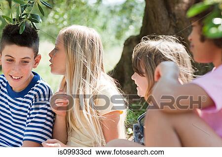 Stock Image - Girl whispering to firiend. Fotosearch