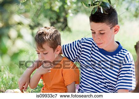 Stock Photo - Two boys, older boy with arm around younger boy. Fotosearch