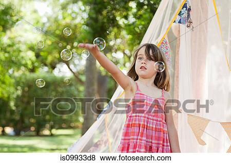 Stock Photo - Young girl with bubble wand. Fotosearch