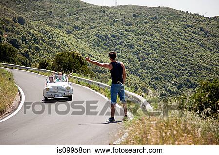 Hitchhiker waiting for convertible car to stop View Large Photo Image Picture - Hitchhiker waiting for convertible car to stop. Fotosearch