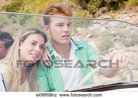 Young couple driving convertible car View Large Photo Image Stock Photo - Young couple driving convertible car. Fotosearch