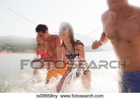 Young friends splashing in the sea View Large Photo Image Stock Photo - Young friends splashing in the sea. Fotosearch