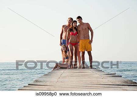 Young friends standing on jetty View Large Photo Image Stock Image - Young friends standing on jetty. Fotosearch
