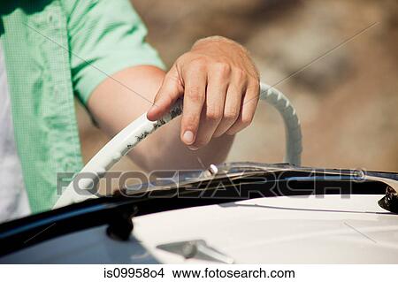 Picture - Young man driving convertible car, close up. Fotosearch