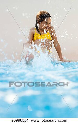 Girl sitting at poolside kicking and splashing View Large Photo Image Stock Image - Girl sitting at poolside kicking and splashing. Fotosearch