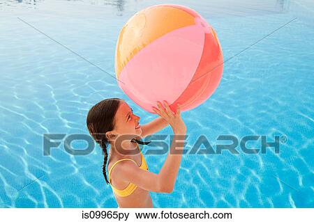 Girl with beach ball by swimming pool View Large Photo Image Stock Photo - Girl with beach ball by swimming pool. Fotosearch