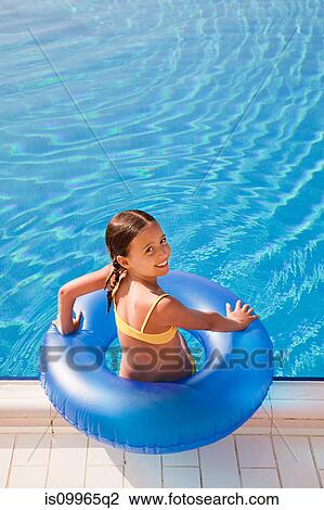 Girl with inflatable ring by swimming pool View Large Photo Image Stock Image - Girl with inflatable ring by swimming pool. Fotosearch