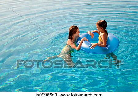 Girls with in inflatable ring in swimming pool View Large Photo Image Stock Image - Girls with in inflatable ring in swimming pool. Fotosearch