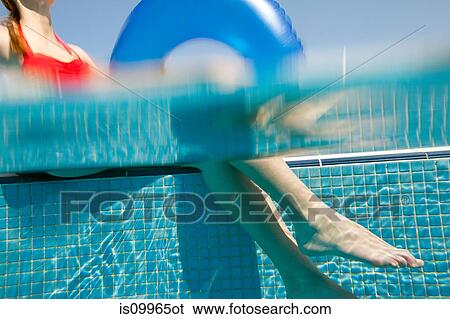 Woman sitting at poolside with inflatable ring, underwater view View Large Photo Image Stock Photograph - Woman sitting at poolside with inflatable ring, underwater view. Fotosearch