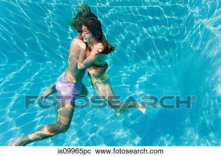 Young couple embracing in swimming pool, underwater view View Large Photo Image Stock Image - Young couple embracing in swimming pool, underwater view. Fotosearch