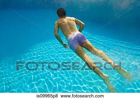 Stock Photo - Young man swimming underwater in swimming pool. Fotosearch