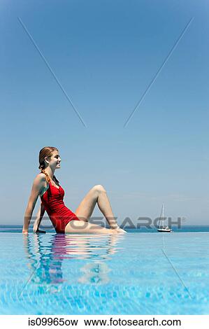Stock Photo - Young woman by swimming pool, portrait. Fotosearch
