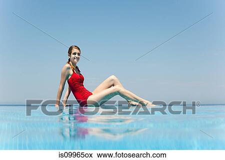 Stock Photo - Young woman by swimming pool, portrait. Fotosearch