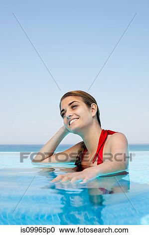 Stock Image - Young woman in swimming pool, portrait. Fotosearch