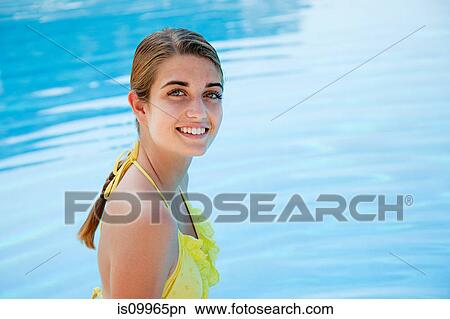 Young woman in yellow bikini by swimming pool, portrait View Large Photo Image Picture - Young woman in yellow bikini by swimming pool, portrait. Fotosearch