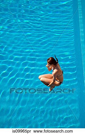 Young woman jumping into swimming pool View Large Photo Image Stock Photography - Young woman jumping into swimming pool. Fotosearch