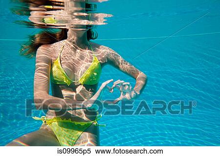 Young woman making heart shape with hands underwater in swimming pool View Large Photo Image Stock Photography - Young woman making heart shape with hands underwater in swimming pool. Fotosearch