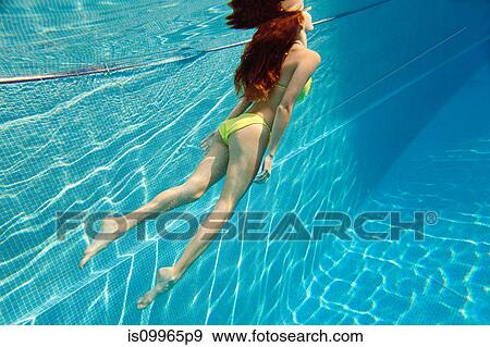 Young woman swimming underwater in swimming pool View Large Photo Image Stock Photo - Young woman swimming underwater in swimming pool. Fotosearch