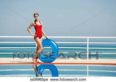 Young woman with inflatable ring by swimming pool, portrait View Large Photo Image Stock Image - Young woman with inflatable ring by swimming pool, portrait. Fotosearch