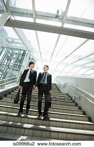 Stock Image - Businessmen coming down steps. Fotosearch
