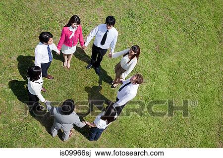 Businesspeople in a circle in field, high angle View Large Photo Image Stock Image - Businesspeople in a circle in field, high angle. Fotosearch
