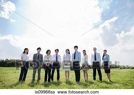 Stock Photograph - Businesspeople in a row in field. Fotosearch