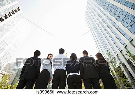 Businesspeople in a row, woman looking over shoulder View Large Photo Image Stock Image - Businesspeople in a row, woman looking over shoulder. Fotosearch