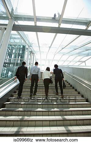 Stock Photo - Four businesspeople on steps. Fotosearch