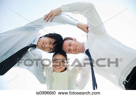 Stock Image - Multi ethnic businesspeople in huddle. Fotosearch