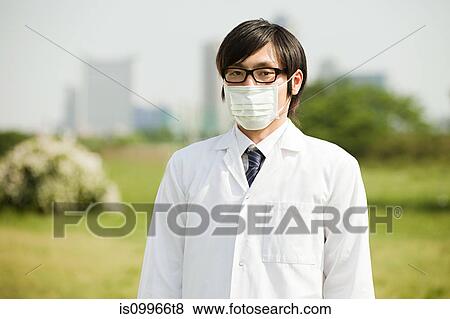 Stock Photo - Portrait of young man wearing pollution mask and glasses. Fotosearch