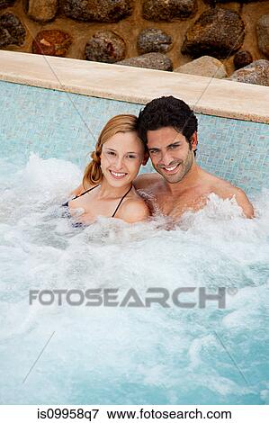 Stock Photo - Young couple in hot tub, portrait. Fotosearch