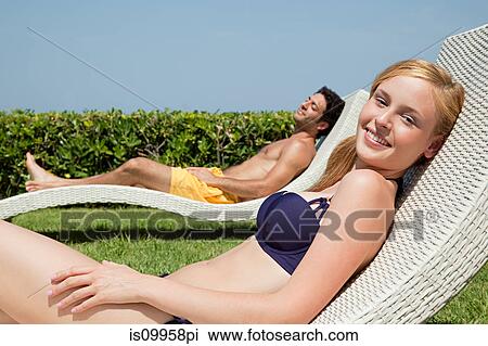 Young couple on sun loungers View Large Photo Image Stock Image - Young couple on sun loungers. Fotosearch