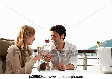 Stock Image - Young couple toasting with champagne. Fotosearch