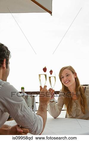 Stock Image - Young couple toasting with champagne. Fotosearch