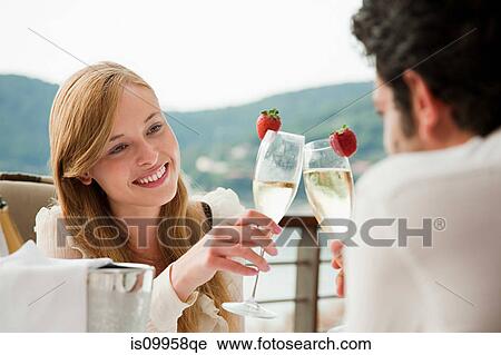 Stock Image - Young couple toasting with champagne. Fotosearch