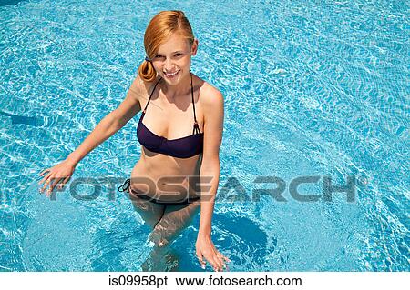 Stock Photograph - Young woman in swimming pool, high angle. Fotosearch