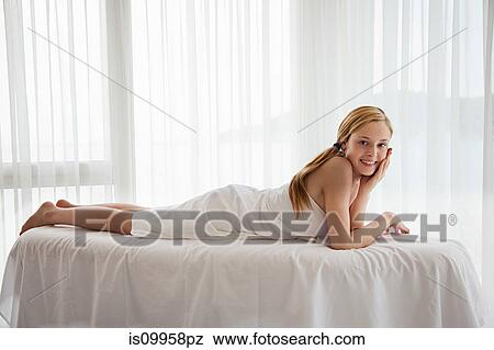 Young woman lying on massage table View Large Photo Image Stock Photo - Young woman lying on massage table. Fotosearch