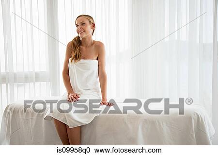 Young woman sitting on massage table View Large Photo Image Stock Image - Young woman sitting on massage table. Fotosearch