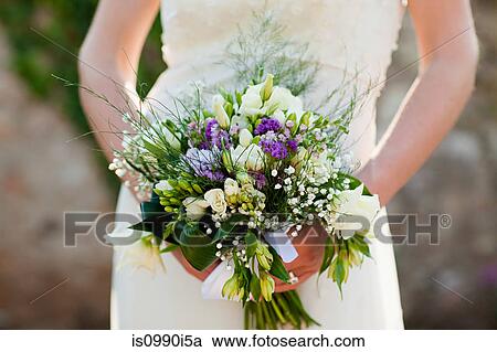 Stock Image - Bride holding bouquet, close up. Fotosearch