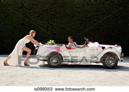 Bride pushing broken down vintage car View Large Photo Image Stock Image - Bride pushing broken down vintage car. Fotosearch