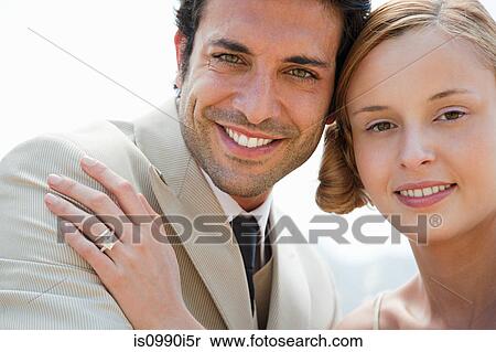 Bride wearing wedding ring with hand on groom's shoulder View Large Photo Image Stock Photography - Bride wearing wedding ring with hand on groom's shoulder. Fotosearch