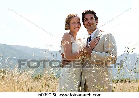 Newlyweds embracing in field View Large Photo Image Stock Image - Newlyweds embracing in field. Fotosearch